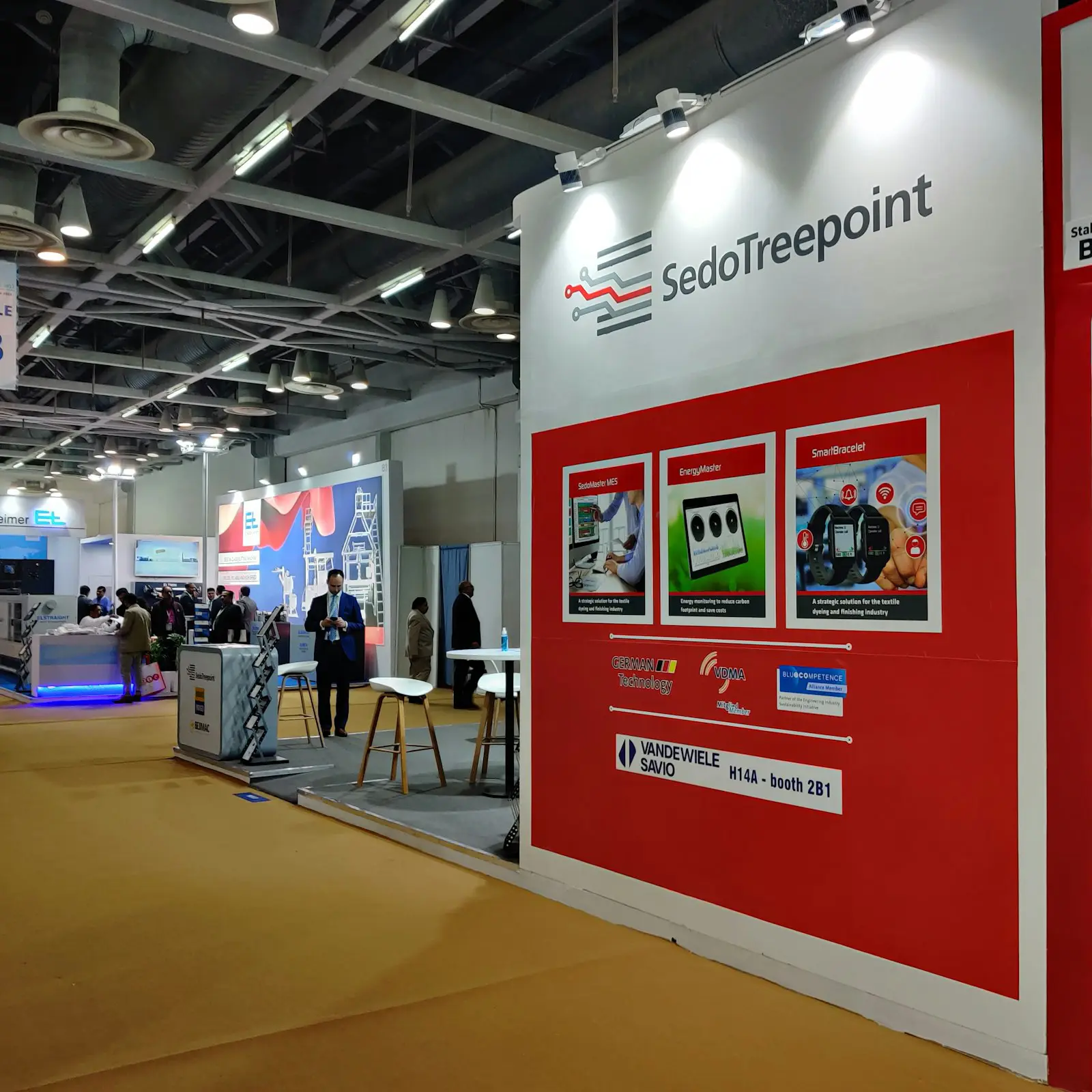 A red and white exhibition stall with visitors